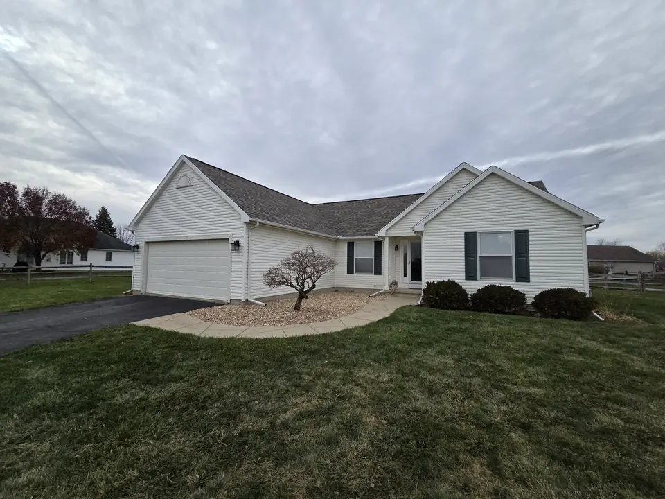 White-sided ranch home with a gray shingle roof and an attached two-car garage.